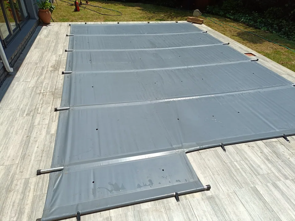 Close view of a grey cover with aluminium poles, reinforced seams and drainage holes